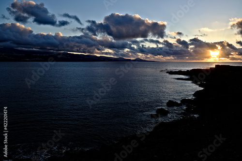 Dramatic and contrasty marine sunset over the bay of a small island.