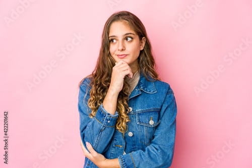 Young caucasian woman looking sideways with doubtful and skeptical expression. © Asier
