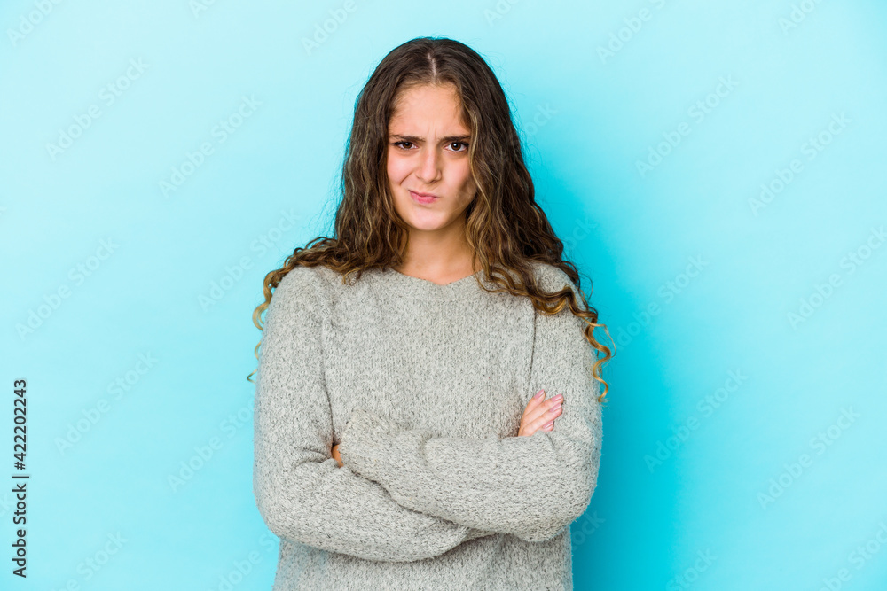 Young caucasian curly hair woman isolated frowning face in displeasure, keeps arms folded. Young caucasian curly hair woman isolated frowning face in displeasure, keeps arms folded.