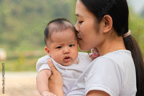 Young Asian mother holding little daughter in the park, Mother play enjoying with her cute baby girl outdoor, copy space 