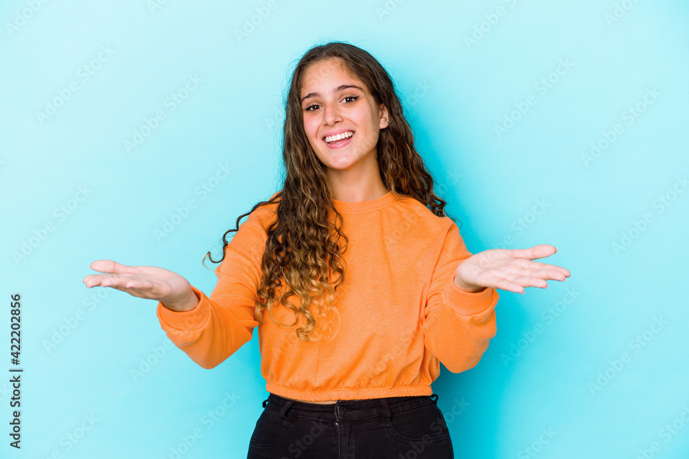 Young caucasian curly hair woman isolated makes scale with arms, feels happy and confident. Young caucasian curly hair woman isolated makes scale with arms, feels happy and confident.