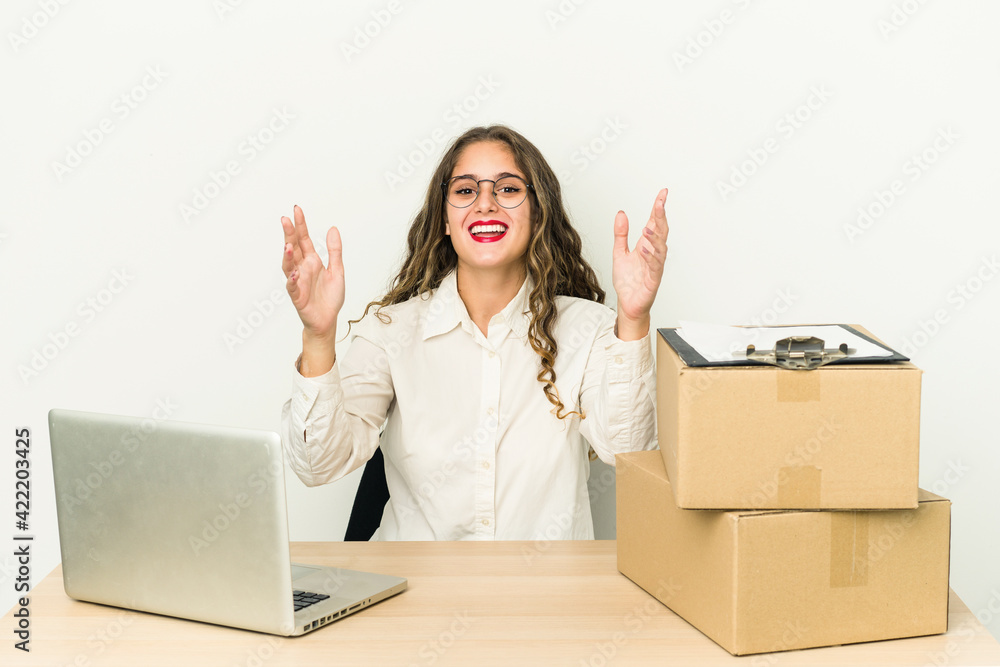 Young caucasian worker of a parcel company isolated receiving a pleasant surprise, excited and raising hands. Young caucasian worker of a parcel company isolated receiving a pleasant surprise, excited and raising hands.