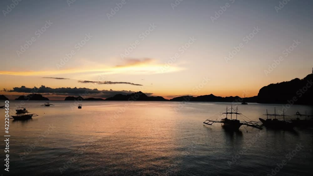 Backward low flying drone shot over water and boats at sunset in El Nido, Palawan, Philippines Backward low flying drone shot over water and boats at sunset in El Nido, Palawan, Philippines