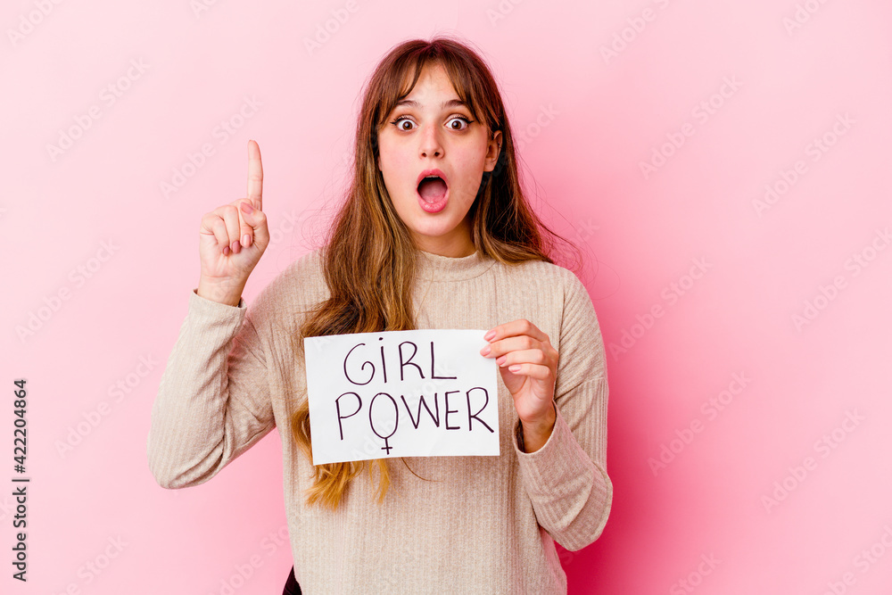 Young caucasian woman holding a girl power placard isolated on pink background having an idea, inspiration concept. Young caucasian woman holding a girl power placard isolated on pink background having an idea, inspiration concept.