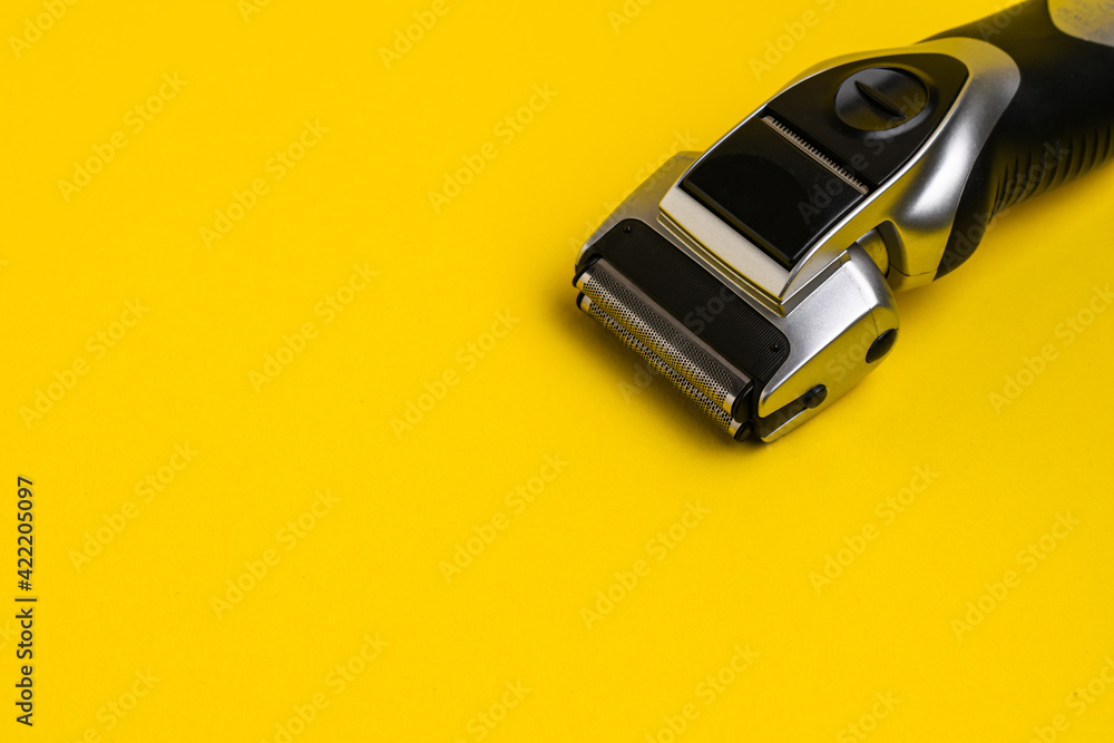 Electric shaver on a yellow background, in the upper right corner Electric shaver on a yellow background, in the upper right corner