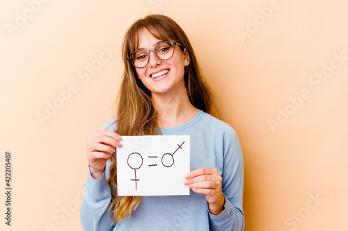 Young caucasian woman holding a equality gender placard isolated happy, smiling and cheerful.