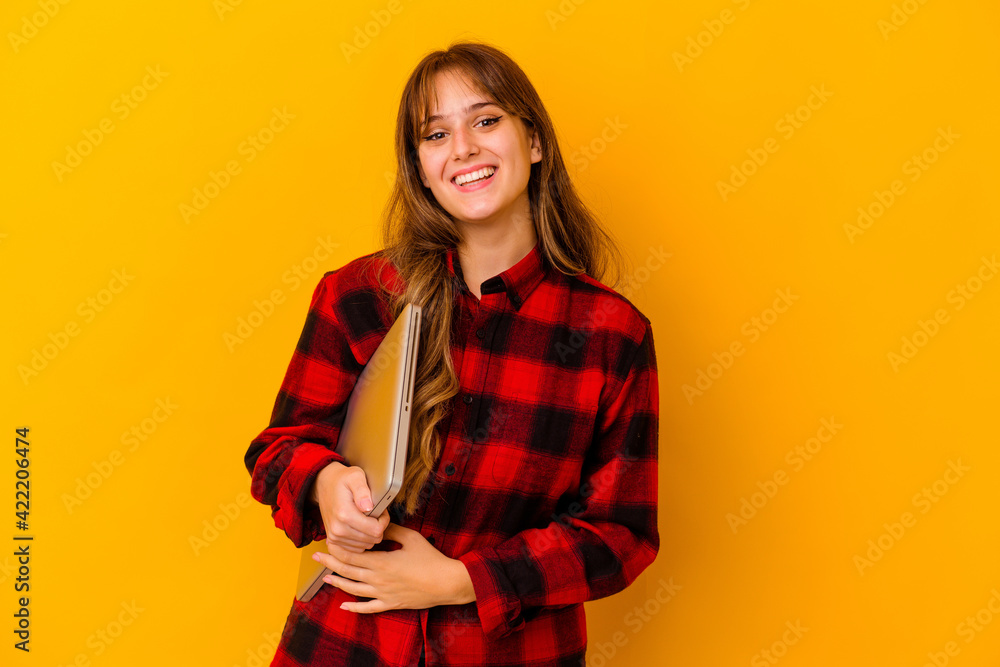 Young caucasian woman holding a laptop isolated happy, smiling and cheerful. Young caucasian woman holding a laptop isolated happy, smiling and cheerful.