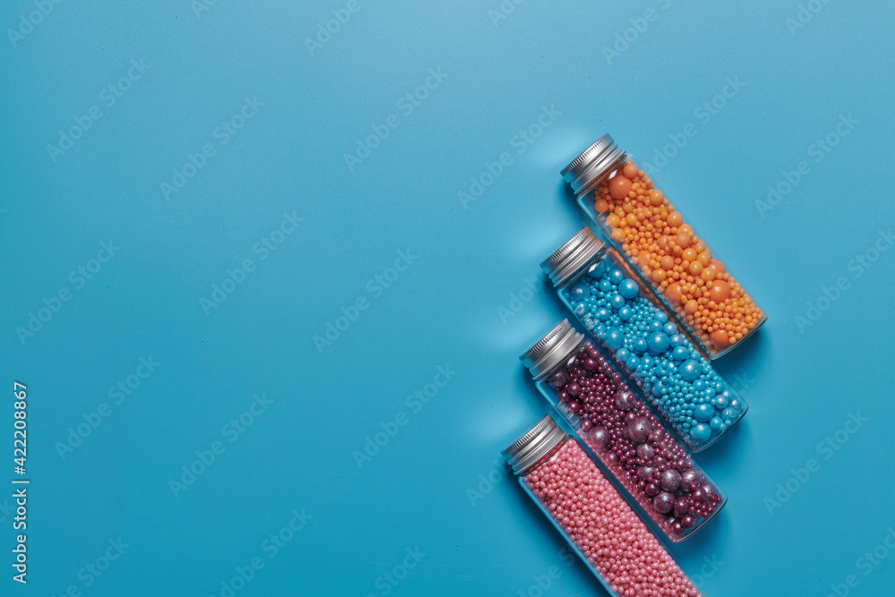 jars and colored balls on a blue background jars and colored balls on a blue background