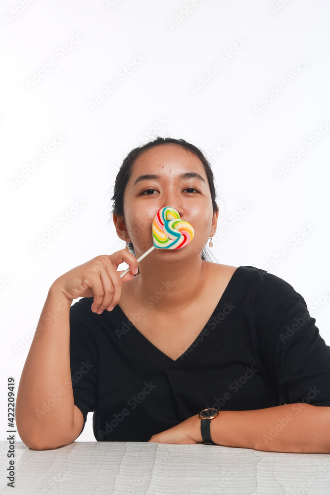 Fashion portrait young woman and lollipop is having fun over white background. Fashion portrait young woman and lollipop is having fun over white background.
