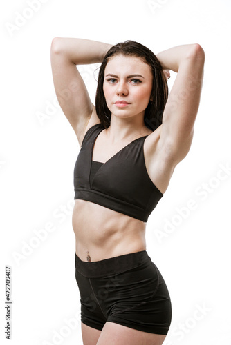 portrait of a young brunette woman in a black training uniform isolated on a white background