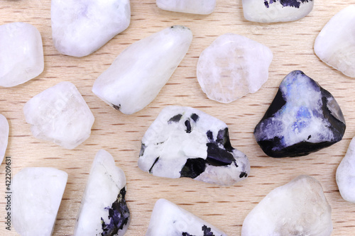 Fototapete Moon stone rare jewel on light varnished wood texture