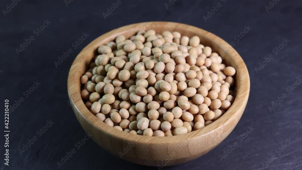 Wooden bowl full of soyabeans soya bean on black slate background Wooden bowl full of soyabeans soya bean on black slate background