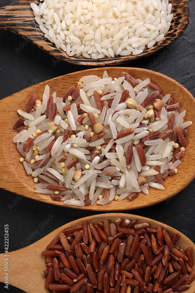 Long grain basmati medium grain jasmine short grain pilaf polau risotto brown low glycaemic index gi rice in wooden spoon on black background copy text space top flat lay view Long grain basmati medium grain jasmine short grain pilaf polau risotto brown low glycaemic index gi rice in wooden spoon on black background copy text space top flat lay view