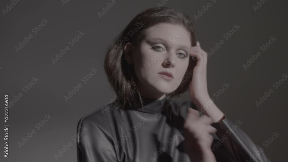 Dark hair woman posing in the black dress in the studio lights. Young attractive woman wearing a black dress. Ungraded video. Dark hair woman posing in the black dress in the studio lights. Young attractive woman wearing a black dress. Ungraded video.