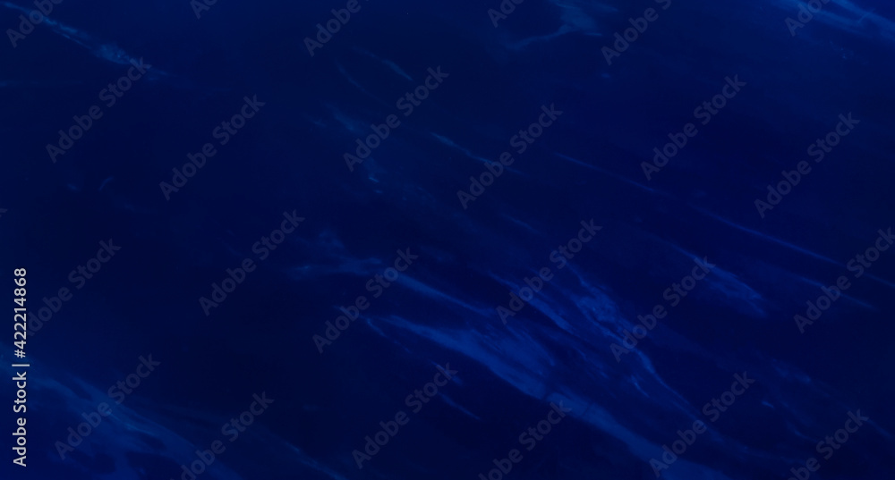 abstract blue marble background with beautiful veins in wave pattern use for aqua or deep sea background. indigo ocean blue marbling with luxury style swirls of marble texture.