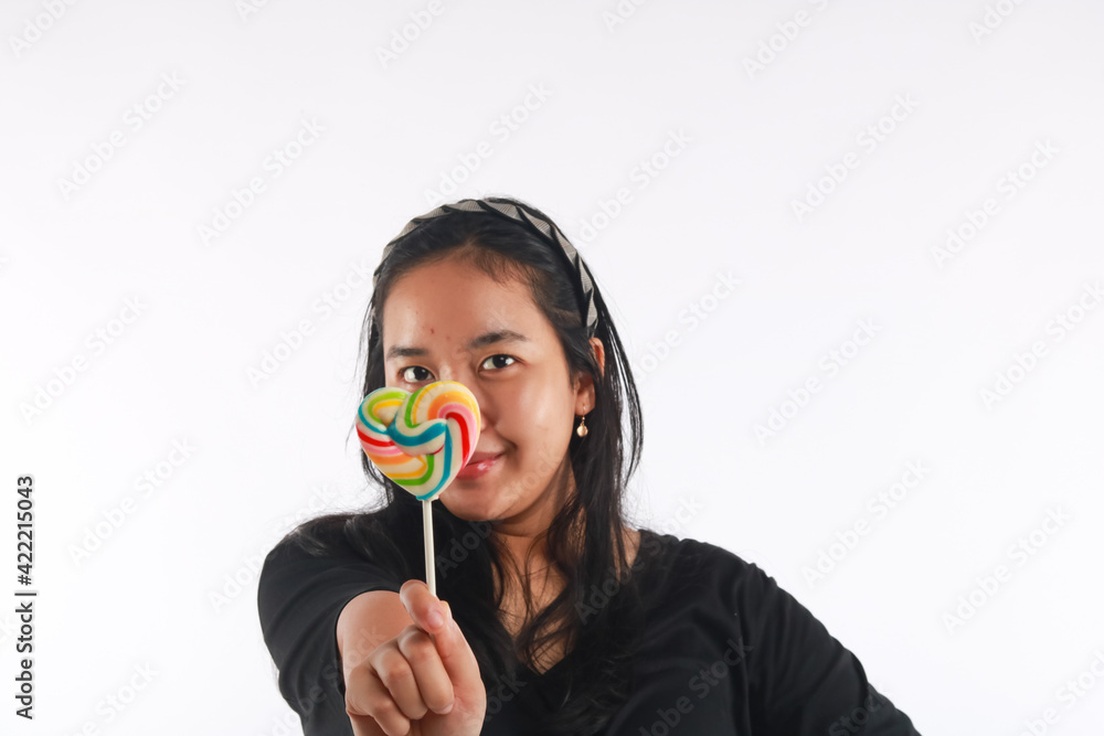 Fashion portrait young woman and lollipop is having fun over white background. Fashion portrait young woman and lollipop is having fun over white background.