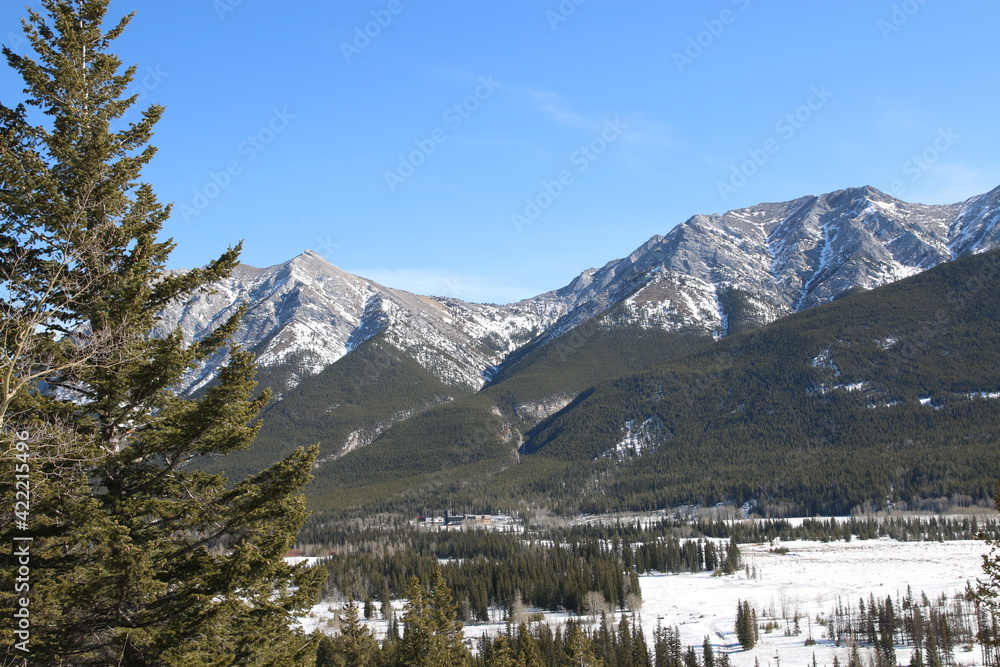 Rocky Mountain frozen river valley on a sunny spring day . Hiking in the mountains, Canada, Alberta