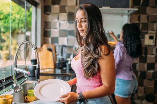 lesbian latinx couple together in the kitchen, having a great time