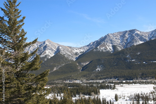 Rocky Mountain frozen river valley on a sunny spring day . Hiking in the mountains, Canada, Alberta
