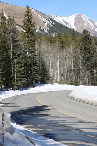 Winding road in the Rocky Mountains with mountain view on a sunny day. Going skiing