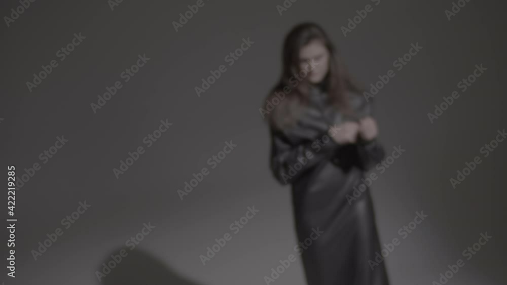 Dark hair woman posing in the black dress in the studio lights. Young attractive woman wearing a black dress. Ungraded video. Dark hair woman posing in the black dress in the studio lights. Young attractive woman wearing a black dress. Ungraded video.