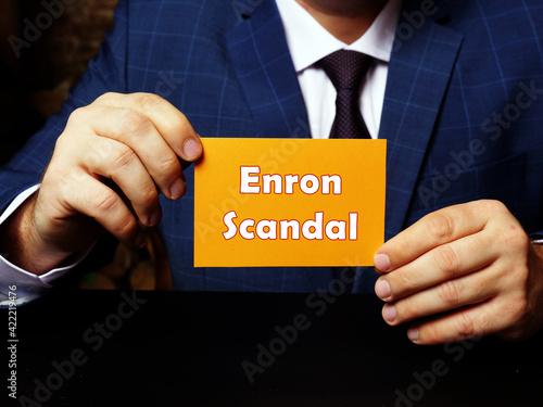 Schilderij op canvas Blank orange business card in a hand with phrase Enron Scandal