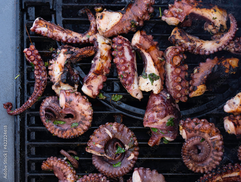 Фотография Cooking octopus on a barbeque grill