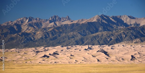 sand dunes and mountain peaks on a sunny day in great sand dunes national park, near alamosa, colorado 