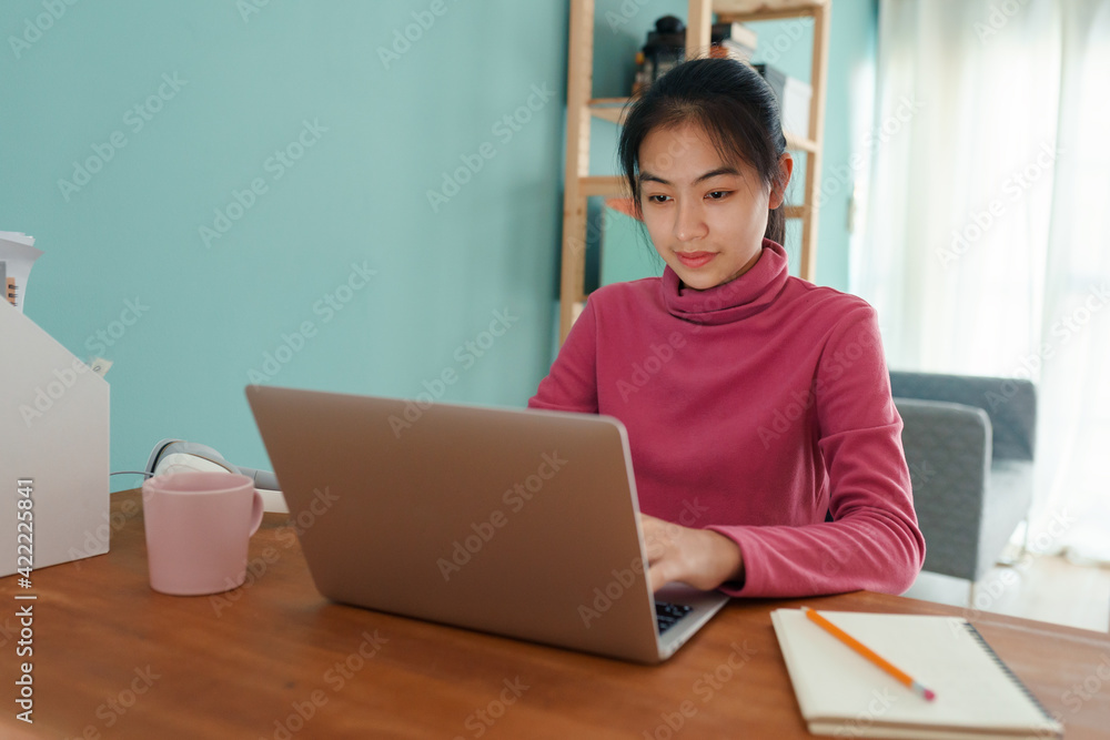 Asian student Wear long sleeves pink online learning via the internet on laptop computer Asian student Wear long sleeves pink online learning via the internet on laptop computer