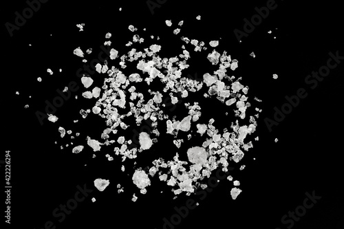 Pieces of  white sea salt on a black background. clear crystalline pebbles. white ice cubes