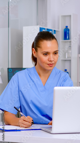 Professional nurse writing on clipboard patient health report, medical team working together in hospital clinic. Healthcare physician in medicine uniform typing list of consulted, diagnosed patients