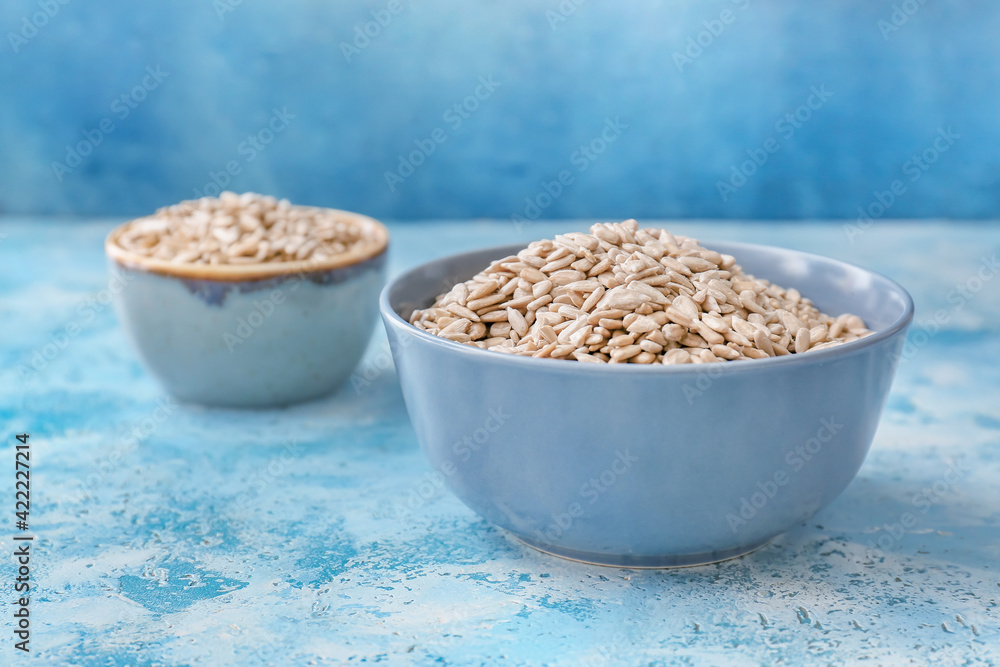 Bowls with sunflower seeds on color background Bowls with sunflower seeds on color background