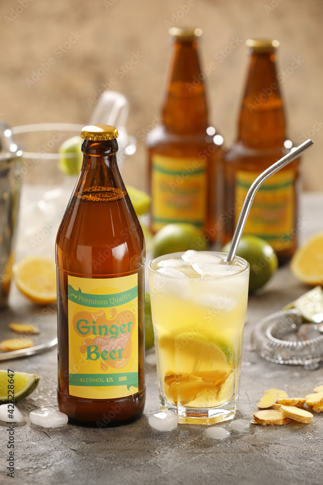 Bottle and glass of fresh ginger beer on grey background Bottle and glass of fresh ginger beer on grey background