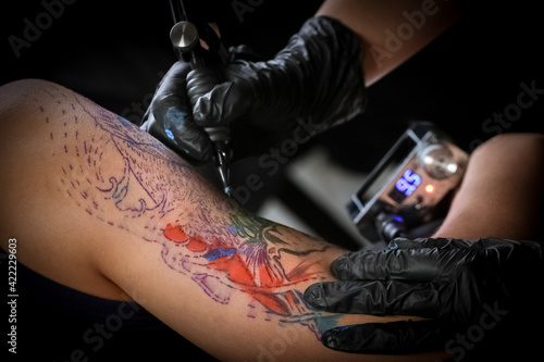 Female tattoo artist making tattoo on a men   s arm
