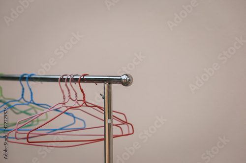 Stainless steel clothes rack with multi-colored hangers Home wall background