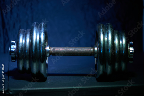 Chrome Iron dumbbells on a blue dark energetic background