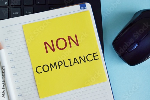 Non Compliance text written on colorful sticker in Notebook. Business concept