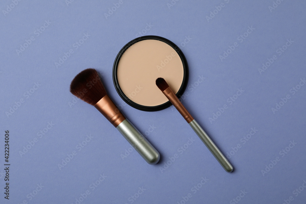 Makeup cosmetics on violet background, top view Makeup cosmetics on violet background, top view