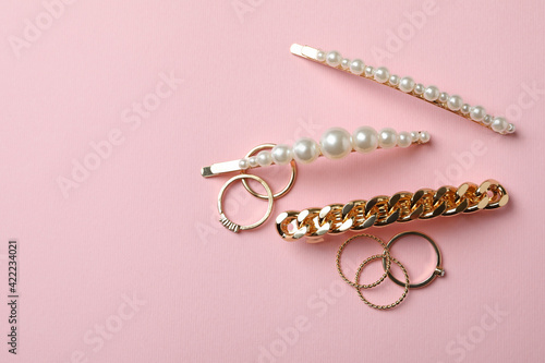 Hair clips and rings on pink background