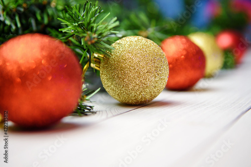 Christmas composition with fir branches, gold and red balloons on a white wooden background. Copyspace.