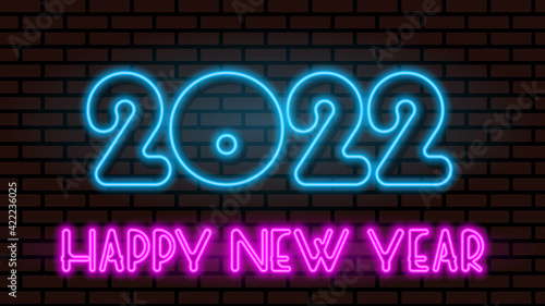 Neon greeting lettering happy new year 2022 on a dark brick wall