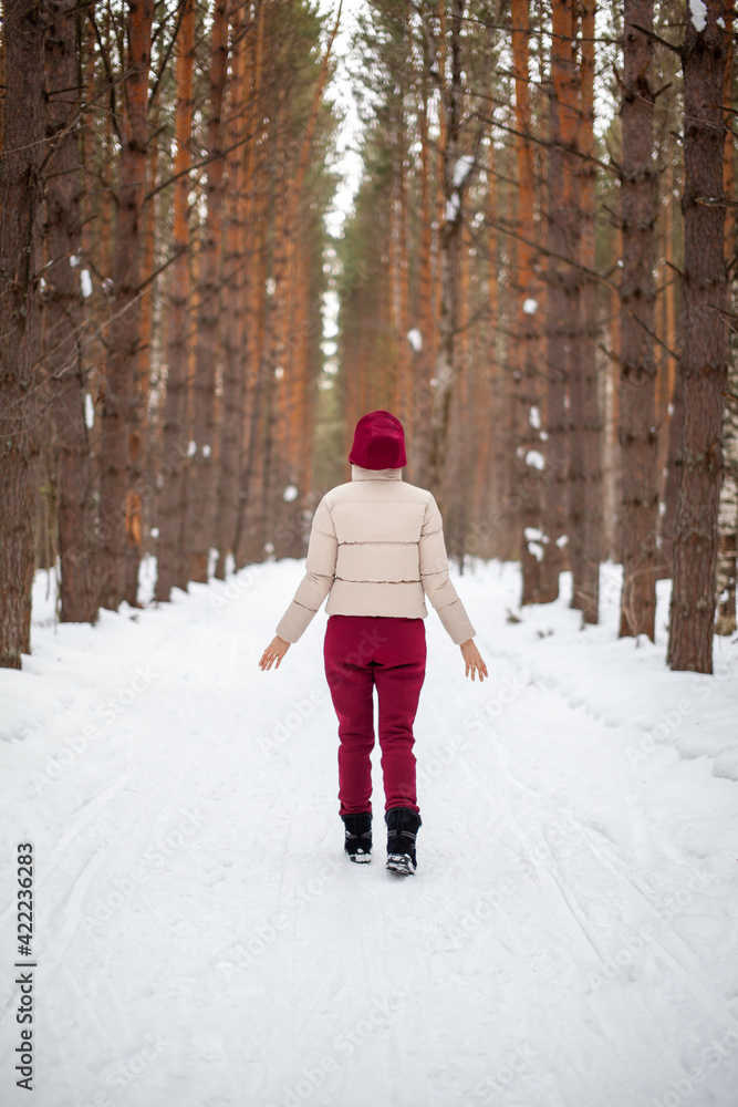 Winter walk in a snow-covered forest, A girl with a red jumpsuit