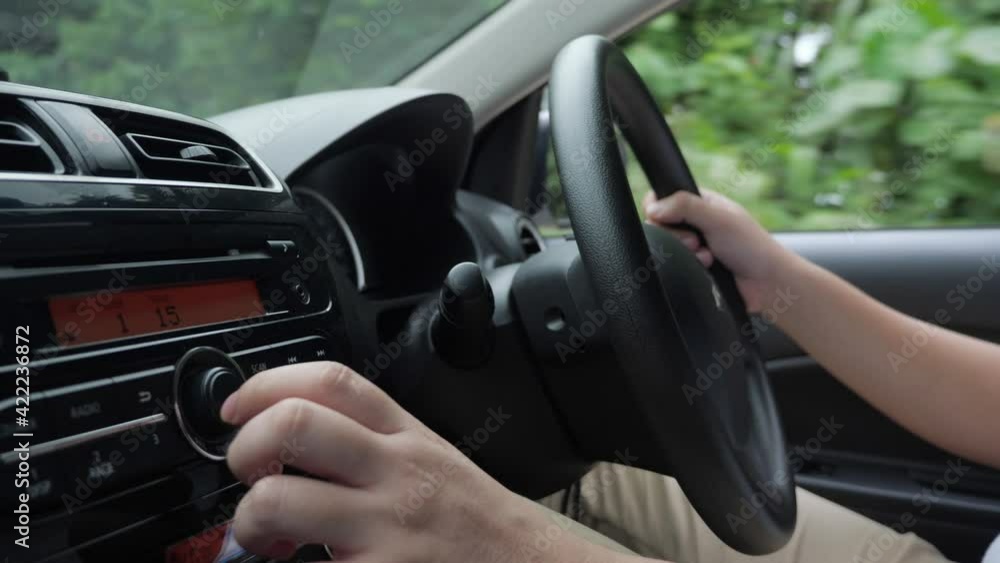 Close up image of driver's hand press button on car audio system, listening music during trip Close up image of driver's hand press button on car audio system, listening music during trip