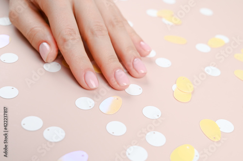 Tender female hand lie calmly on creative pink background. Beauty treatments and skincare