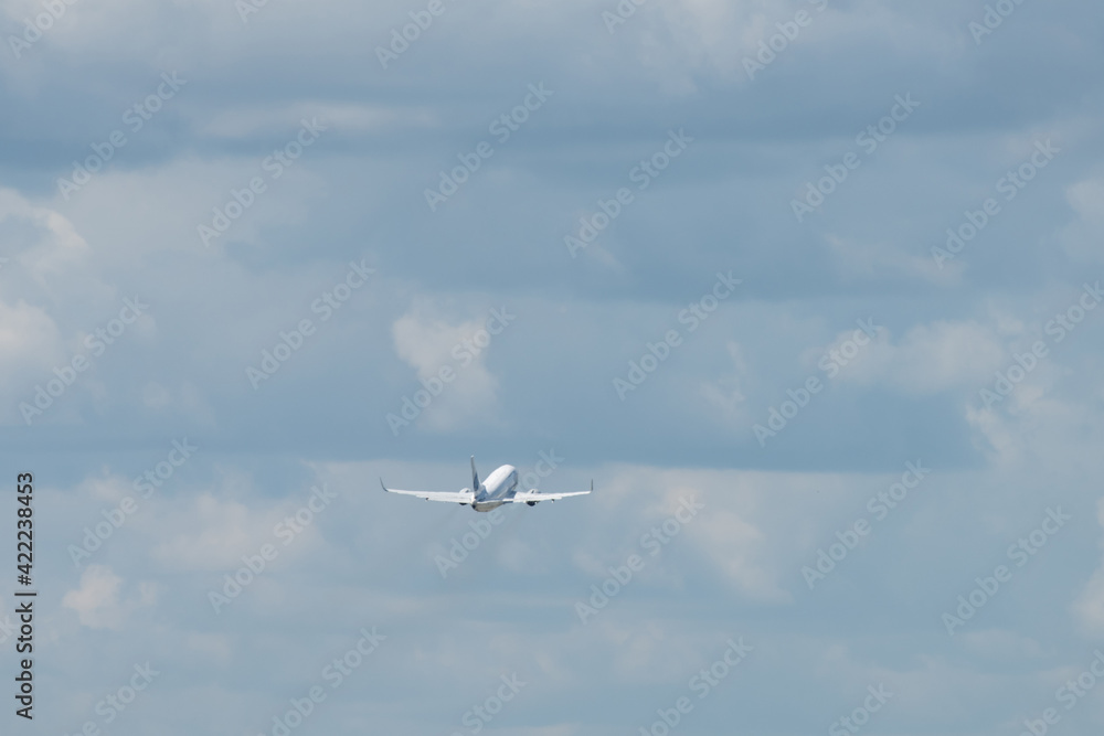 A modern white jet airliner takes off from the airport against the backdrop of a cloudy sky. A modern white jet airliner takes off from the airport against the backdrop of a cloudy sky.