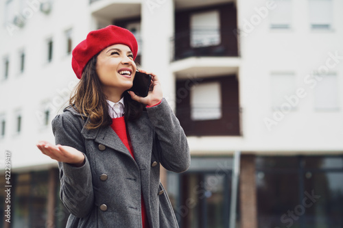 Outdoor portrait of happy woman who is talking on phone.