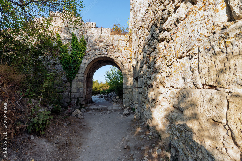 Mangup-Kale is an ancient cave town in Crimea. View of antique citadel ruins at sunset.