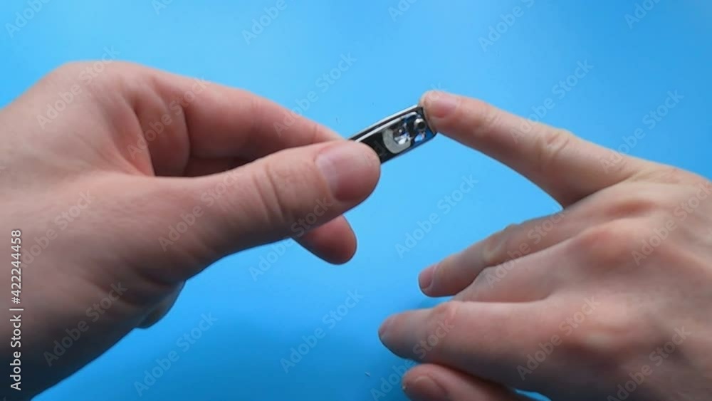 the man cuts his nails with scissors on a blue background the man cuts his nails with scissors on a blue background