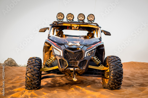 Modern dune buggy with light bar front view, parked on sand in the desert, Fossil Rock, Sharjah, United Arab Emirates. photo