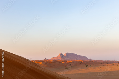 Sunset over Fossil Rock mountain ridge and golden desert  Sharjah  United Arab Emirates.